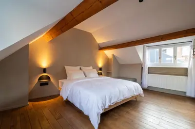 a bedroom with a white bed and a window at Charming House in Le Sablon in Brussels