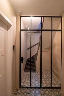 a staircase is seen through a glass door at Private en-suite room in the heart of Le Sablon in Brussels