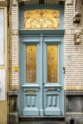 a blue door with two windows on a building at SHWAY - Le Leopold in Antwerp