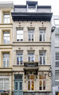 a large brick building with windows and a balcony at SHWAY Le Pierre in Antwerp