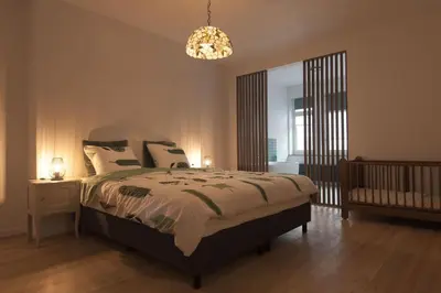 a bedroom with a bed and a chandelier at Vakantiehuis huYze-K in Zottegem