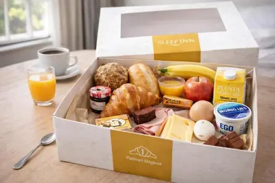 a box of breakfast food on a table with orange juice at Japandi Apartment, Cityview Elevator in Antwerp