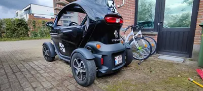 a small car is parked next to a bike at Logeerkamer XXL 25 m2 in Zemst